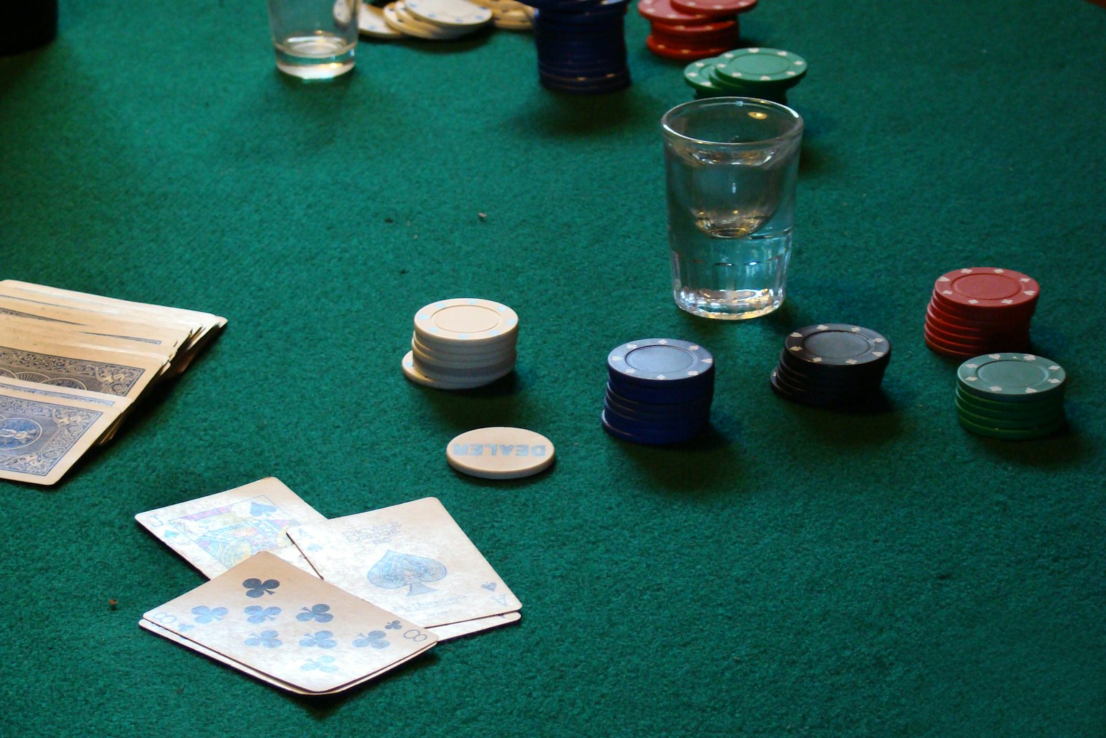 Meja permainan kartu dengan tumpukan chip poker dan kartu remi