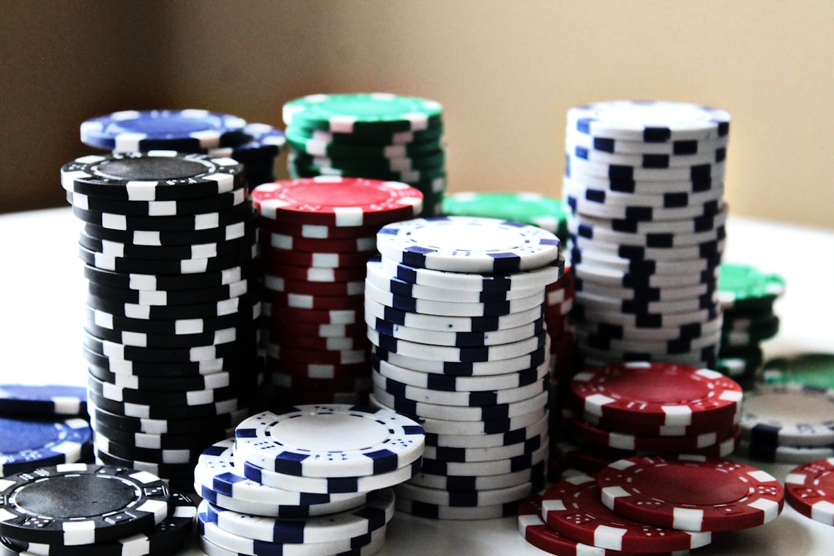 Tumpukan chip poker berbagai warna di atas meja permainan