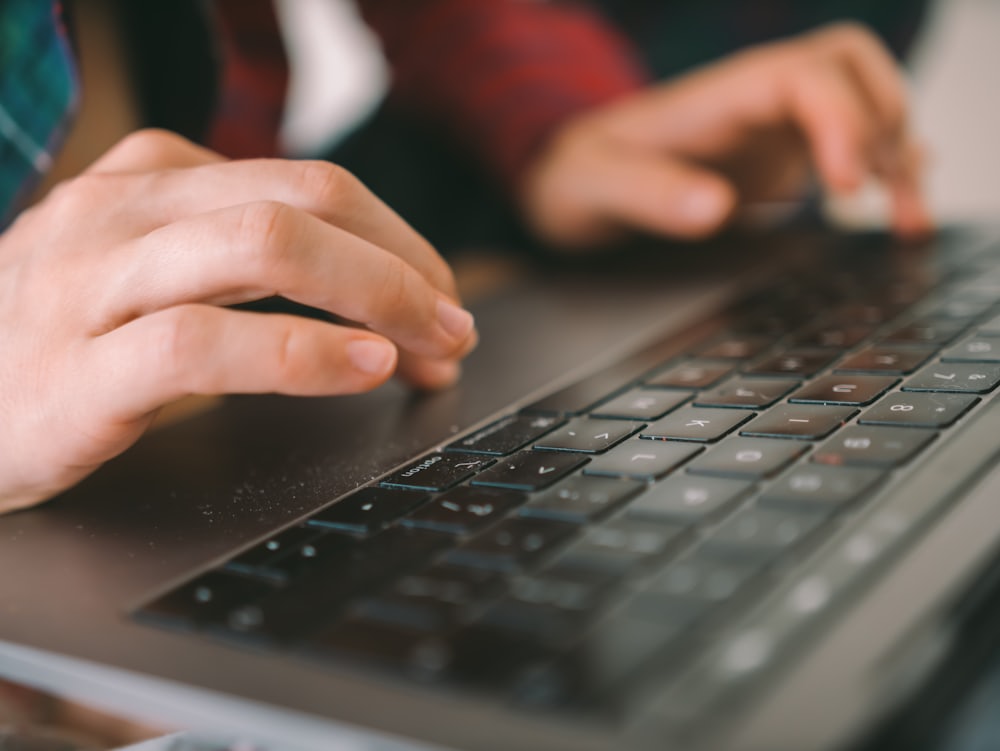Tangan mengetik pada papan tombol laptop